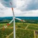 A working windmill in a field. Cloody weather, a lot of greenery around it
